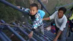 Sejumlah anak didampingi orang tua memanjat tangga baru menuju rumah yang berada di ketinggian 800 meter di Desa Atuleer, Tiongkok, Rabu (19/11). Pemerintah Tiongkok akhirnya membangun tangga untuk warga yang tinggal di desa tersebut. (REUTERS)
