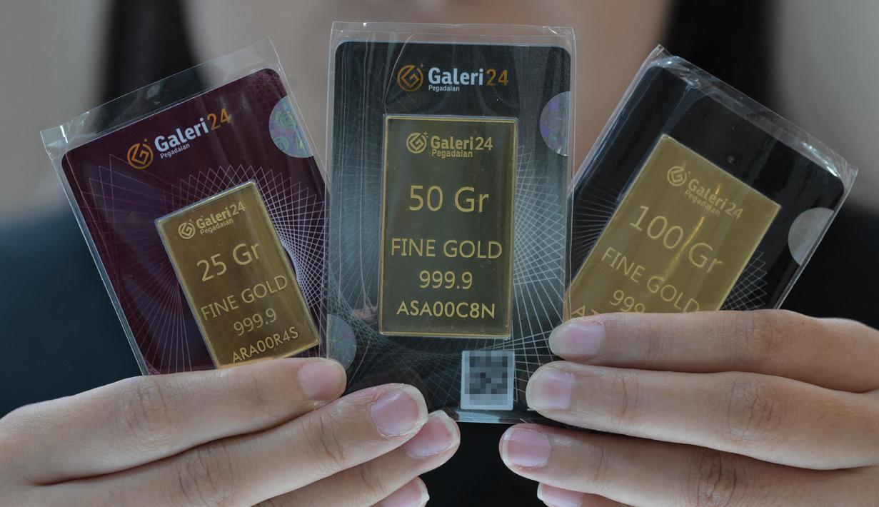 Seorang karyawan menunjukkan emas batangan 25, 50, dan 100 gram produksi Galeri 24, anak perusahaan dari PT Pegadaian (Persero), di Jakarta pada 14 April 2025. (BAY ISMOYO/AFP)