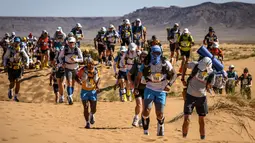 Para peserta bersaing dalam lomba lari Marathon des Sables ke-34 tahap kedua di Gurun Sahara, Maroko, Minggu (7/4). Lomba yang diselenggarakan sejak tahun 1986 ini digelar di Gurun Sahara pada bulan April. (JEAN-PHILIPPE KSIAZEK/AFP)