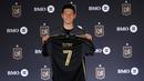 Pemain baru Los Angeles Lakers, Son Heung-min berfoto dengan memegang jersey miliknya dalam acara konferensi pers di BMO Stadium, Los Angeles, Amerika, Rabu (06/08/2025) waktu setempat. (AFP/Getty Images/Kevork Djansezian)