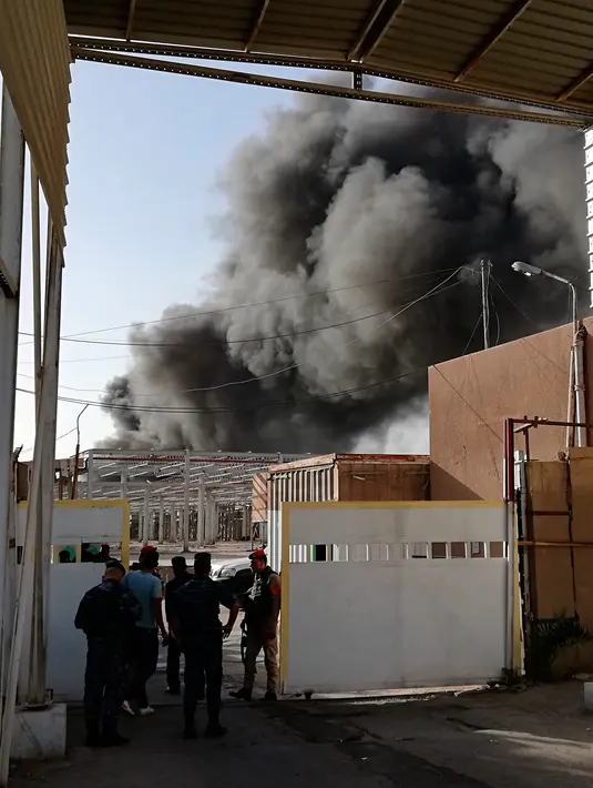 Kepulan asap hitam membumbung dari kebakaran gudang surat suara terbesar Irak di Baghdad, Minggu (10/6). Gudang tersebut menyimpan surat suara dari Al Russafa, salah satu wilayah pemilihan terbesar di bagian timur Baghdad. (AP/Karim Kadim)