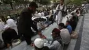 Salah satu petugas memberikan takjil kepada warga yang menunggu waktu berbuka puasa di kota Kabul, Afganistan, (29/6/2014). (REUTERS/Omar Sobhani)