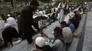 Salah satu petugas memberikan takjil kepada warga yang menunggu waktu berbuka puasa di kota Kabul, Afganistan, (29/6/2014). (REUTERS/Omar Sobhani)