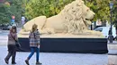 Pejalan kaki berjalan melewati patung singa raksasa dari lego, replika salah satu patung singa dari jembatan tertua Hungaria - Chain Bridge - di Budapest pada 28 Oktober 2022. Patung yang dibuat dengan skala 1:1 itu berukuran panjang 5,80 meter, lebar 1,70 meter, tinggi 2,45 meter dan berat 1,3 ton. (ATTILA KISBENEDEK / AFP)