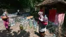 Warga  usai mengambil air untuk minum dan kebutuhan mck rumah  di sumber mata air Sumur Bendung, Gunung Batur, Kota Cilegon, Banten, Minggu, (15/7/2026). (KLY/Arie Basuki)