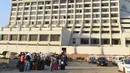 Para tamu berkumpul di luar sebuah hotel mewah yang mengalami kebakaran di kota Karachi, Pakistan, Senin (5/12). Sedikitnya 11 orang tewas dan puluhan lainnya luka-luka akibat musibah tersebut. (RIZWAN Tabassum/AFP)