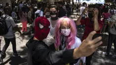 Penggemar anime dan video game Kuba berpakaian seperti pahlawan atau karakter favorit mereka, berpose untuk selfie selama parade Cosplay di sela-sela Pameran Buku Internasional Havana, di Havana, Sabtu (23/4/2022). (AP Photo/ Ramon Espinosa)