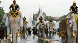 Rombongan gajah Ayutthaya yang ditunggangi pawangnya berjalan setelah memberi penghormatan kepada mendiang Raja Thailand Bhumibol Adulyadej di depan Royal Palace, Bangkok, Thailand (8/11). (Reuters/Jorge Silva)