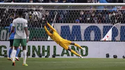 Penjaga gawang Arab Saudi Mohammed al-Owais gagal menangkap bola tendangan pemain Jepang Junya Ito dalam laga kualifikasi Piala Dunia zona Asia Grup B di Saitama Stadium, Saitama, Jepang, Selasa (1/2/2022). Jepang menang dengan skor 2-0. (AFP/Philip Fong)