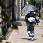 Seorang wanita mengenakan kimono berjalan di bawah terik matahari di Tokyo, Selasa (10/8/2021). Menurut biro meteorologi Jepang, cuaca panas panas terus berlanjut di wilayah metropolitan saat suhu naik menjadi 38 derajat Celcius (100,4 derajat Fahrenheit). (AP Photo/Eugene Hoshiko)