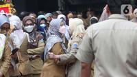 Pegawai Pemprov DKI mengantre saat halal bihalal di Balai Kota DKI, Jakarta, Senin (9/5/2022). Gubernur Anies Baswedan menggelar halal bihalal bersama para ASN Pemprov DKI Jakarta seusai libur Lebaran 2022. (Liputan6.com/Herman Zakharia)