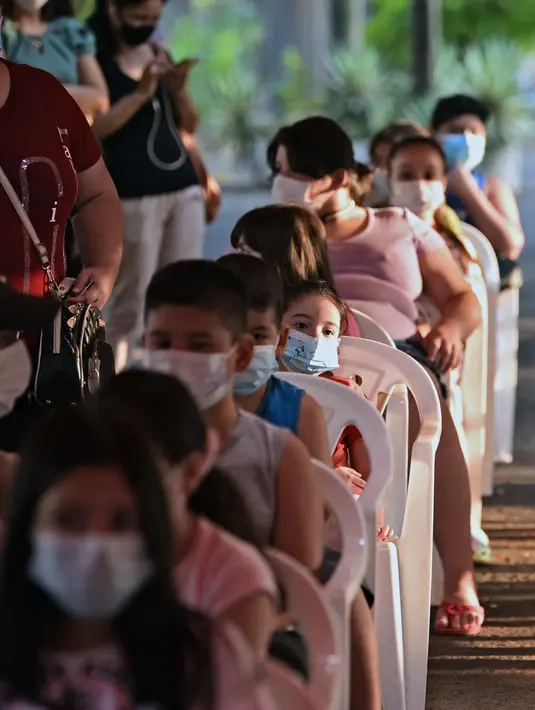 Anak-anak mengantre untuk vaksin covid-19 CoronaVac di San Lorenzo, Paraguay, Senin (31/1/2022). Paraguay mulai memvaksinasi anak-anak berusia 5 hingga 11 tahun pada hari Senin, karena peningkatan tajam infeksi covid-19 yang didorong oleh varian omicron. (NORBERTO DUARTE / AFP)