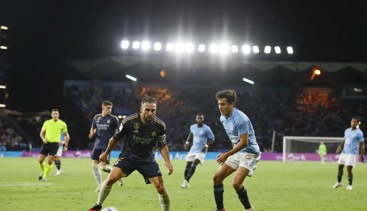 Bek Real Madrid, Dani Carvajal (kiri) mengontrol bola dari kawalan pemain Celta Vigo, Manu Sanchez selama pertandingan lanjutan La Liga Spanyol di stadion Balaidos di Vigo, Spanyol, Sabtu6, 2 Agustus 2023. (AP Photo/Lalo R. Villar)
