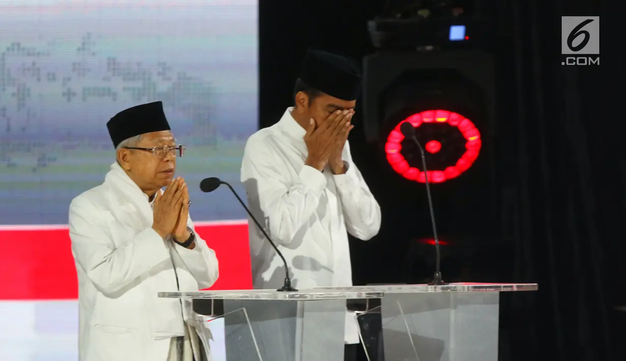 Capres nomor urut 01 Joko Widodo dan Cawapres Ma'ruf Amin saat berdoa pada Debat Pilpres 2019 kelima di Hotel Sultan, Jakarta, Sabtu (13/4). Debat kelima merupakan debat terakhir dalam masa kampanye dan mengambil tema Ekonomi, Kesejahteraan Sosial, Keuangan dan Investasi. (Liputan6.com/Johan Tallo)
