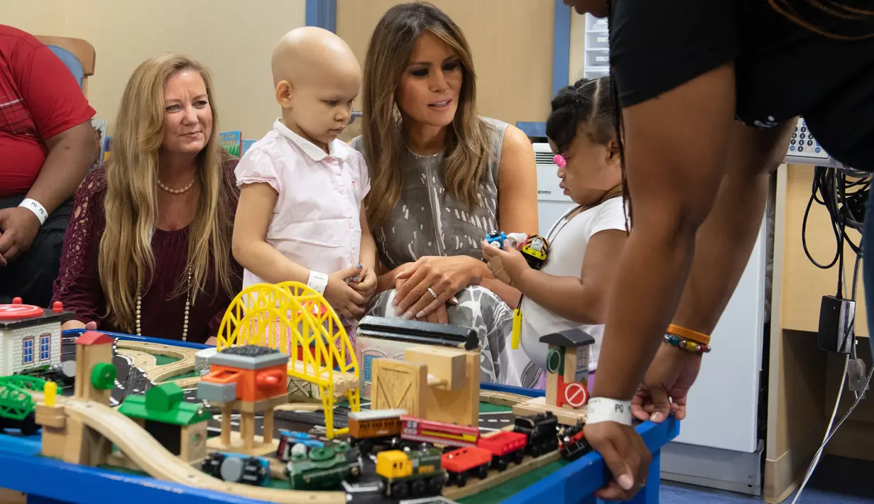 Ibu Negara AS, Melania Trump bermain dengan pasien anak, Essence dan Natalayah saat mengunjungi Rumah Sakit Anak Monroe Carell Jr. di Nashville, Selasa (24/7). Kedatangan Melania untuk berdiskusi terkait Neonatal Abstinence Syndrome (NAS). (AFP/SAUL LOEB)