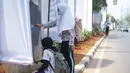 Pelajar mengecat  coretan yang mengotori tembok  saat kericuhan dalam unjuk rasa di Senayan, Jakarta, Jumat (4/10/2019). Para siswa dan alumni SMA menutup coret-coretan  itu sekaligus mengampanyekan cinta damai dalam praktik demokrasi di Indonesia. (Liputan6.com/Immanuel Antonius)
