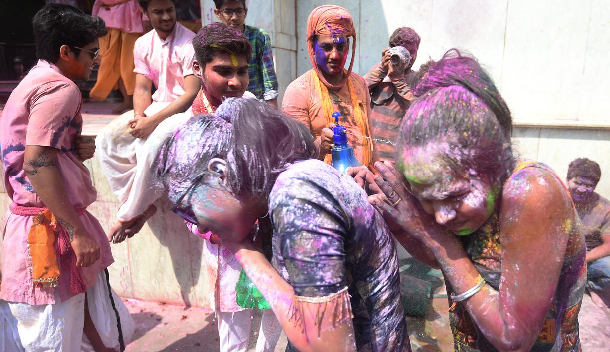 Umat Hindu merayakan Holi, festival warna musim semi, di sebuah kuil di desa Nandgaon, negara bagian Uttar Pradesh, 5 Maret 2020. Ribuan orang India menyambut musim semi pada Kamis (5/3) dengan merayakan Festival Holi yang identik dengan aksi saling melemparkan bubuk warna warni. (Money SHARMA/AFP)