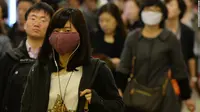 Para wanita mengenakan masker muka guna melindungi diri mereka dari virus flu burung H7N9 di pusat kota Shanghai. (Liputan6/CNN)