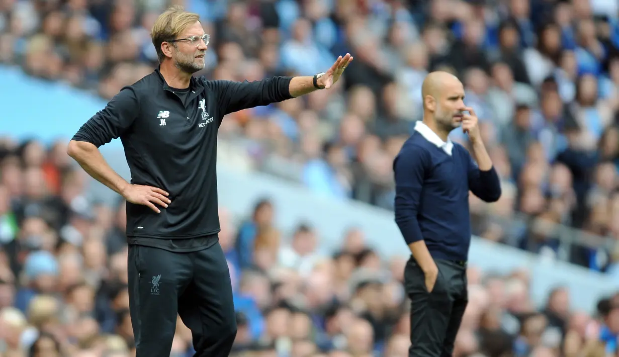 Pelatih Liverpool Juergen Klopp (kiri) dan disebelahnya pelatih Manchester City Pep Guardiola memberi arahan kepada timnya saat pertandingan Liga Inggris di Stadion Etihad, Manchester (9/9). (AP Photo/Rui Vieira)