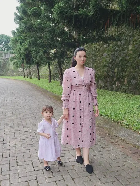 Jalan-jalan bareng si kecil, Asmirandah tampil cantik mengenakan dress polkadot berwarna pink. Ia melengkapi penampilannya dengan flat shoes warna hitam. (Instagram/asmirandah89).