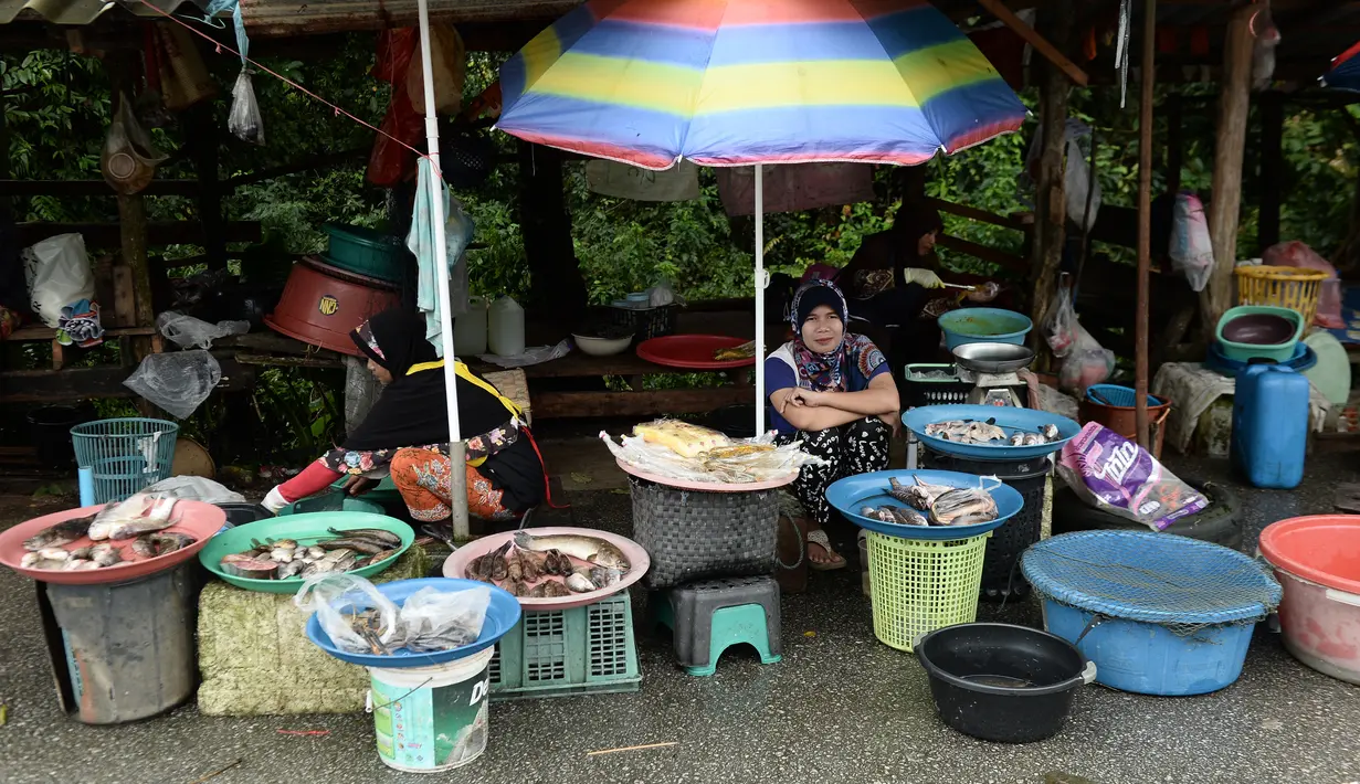 Sejumlah wanita muslim menjual ikan di pinggir jalan di Narathiwat, provinsi selatan Thailand (19/12). Narathiwat adalah tiga provinsi Thailand yang mempunyai jumlah umat Muslim yang besar. (AFP Photo/Lillian Suwanrumpha)