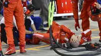 Mekanik Ferrari Francesco tergeletak di tanah setelah ditabrak pembalap Ferrari Kimi Raikkonen saat pit stop di Grand Prix F1 Bahrain di Sirkuit Internasional Formula One Bahrain, Sakhir, Minggu (8/4/2018). (Pool / Giuseppe Cacace)