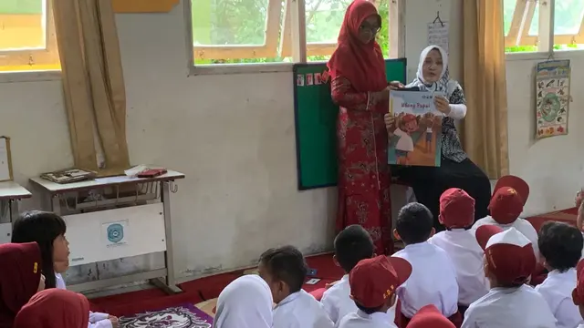 Guru di Sekolah SDN 018 Tenggarong Seberang, Kutai Kertanegara sedang membacakan dongeng untuk kegiatan meningkatkan literasi anak pada Senin (27/11/2023).