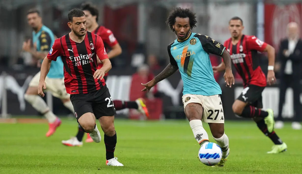 Bek AC Milan Alessandro Florenzi berebut bola dengan gelandang Venezia Gianluca Busio pada laga pekan ke-5 Serie A 2021/22 di San Siro, Kamis (23/9/2021) dini hari WIB. AC Milan menaklukkan tamunya Venezia 2-0. (AP Photo/Antonio Calanni)