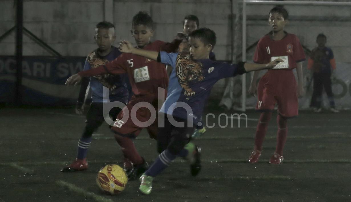 Pemain ASIOP Apacinti (merah) berebut bola dengan pemain Afza United Malaysia dalam final Cup U-10 Serpong City International Soccer Tournament di Sabnani Park, Tangerang Selatan. Minggu (4/12/2016). (Bola.com/Arief Bagus)