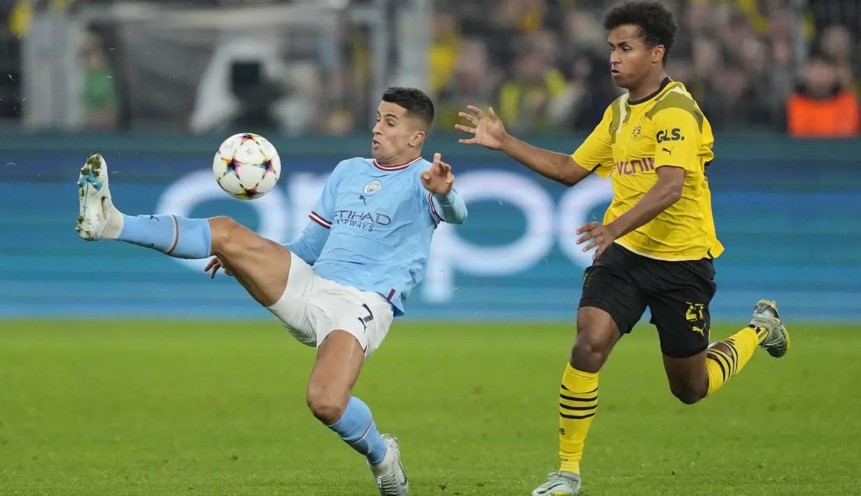Bek Manchester City Joao Cancelo berebut bola dengan penyerang Borussia Dortmund Karim Adeyemi  pada matchday 5 Grup G Liga Champions 2022/2023 di Signal Iduna Park, Rabu (26/10/2022) dini hari WIB. Manchester City memastikan langkah ke fase gugur pertama atau babak 16 besar Liga Champions 2022/2023 usai bermain imbang. (AP Photo/Martin Meissner)