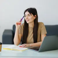 Seorang perempuan tampak sedang berpikir sambil memegang pulpen ke arah dahinya (Foto Dok: Freepik/diana.grytsku).