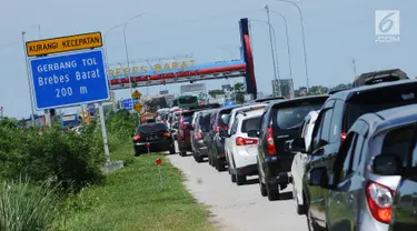 Kendaraan antre menuju pintu keluar Tol Brebes Barat, Jawa Tengah, Sabtu (23/12). Untuk mengurangi kemacetan di pintu Tol Brebes Timur petugas mengalihkan arus lalu lintas keluar Tol Brebes Barat. (Liputan6.com/Helmi Fithriansyah)