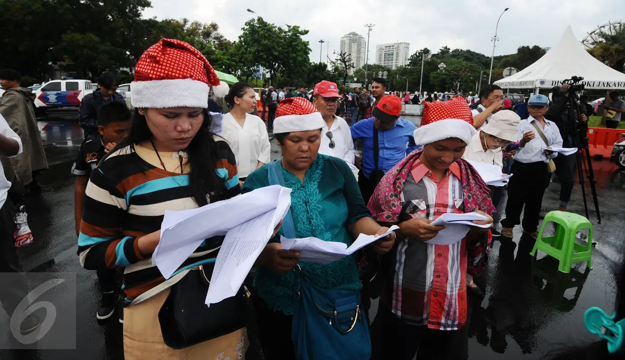Jemaat GKI Yasmin Bogor dan HKBP Filadelfia Bekasi saat misa perayaan Natal 2016 di Silang Barat Laut Monas, Jakarta, Minggu (25/12). Ibadah di depan Istana Merdeka sudah mereka lakukan sejak Februari 2012. (Liputan6.com/Helmi Fithriansyah)