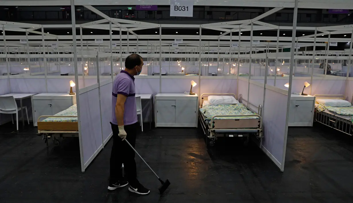 Seorang pekerja membersihkan rumah sakit lapangan sementara yang didirikan di Asia World Expo di Hong Kong, Sabtu (1/8/2020). Pusat pameran di dekat Bandara Internasional Hong Kong itu diubah menjadi fasilitas untuk menampung pasien COVID-19 dengan gejala ringan.  (AP Photo/Kin Cheung)