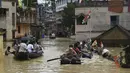Warga menaiki perahu di atas jalan yang terendam banjir menyusul hujan lebat di Ghatal, distrik Paschim Medinipur, sekitar 100 km dari Kolkata (2/8/2021). Banjir parah akibat hujan lebat membuat jalanan di Ghatal berubah bak sungai. (AFP/Dibyangshu Sarkar)