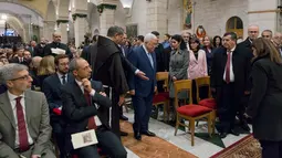 Presiden Palestina Mahmoud Abbas (tengah) tiba untuk menghadiri Misa Malam Natal di Gereja Saint Catherine di kota Betlehem Tepi Barat (25/12). (AFP Photo/Nasser)