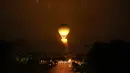 Kancah Api Olimpiade dibawa oleh balon udara sebagai penghormatan kepada penerbangan balon udara hidrogen pertama di dunia yang berlangsung di Tuileries pada Desember 1783.  (AP Photo/Rebecca Blackwell)