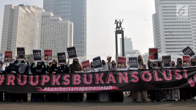 Aktivis menggelar aksi penolakan Rancangan Undang-undang Penghapusan Kekerasan Seksual (RUU PKS) di area car free day, Bundaran HI, Jakarta, Minggu (28/4/2019). Para aktivis membawa poster penolakan dan melakban mulut sebagi simbol dibungkamnya suara mereka. (merdeka.com/Iqbal S. Nugroho)