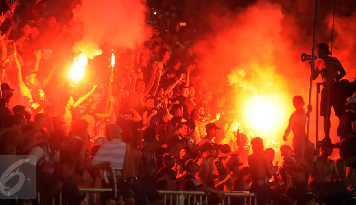 Suporter tim Bajul Ijo bernyanyi dan menyalakan suar saat menyaksikan laga penyisihan Dirgantara Cup 2017 antara Persebaya melawan Cilegon Utd di Stadion Maguwoharjo, Sleman, Sabtu (4/3). Persebaya kalah 1-2. (Liputan6.com/Helmi Fithriansyah)