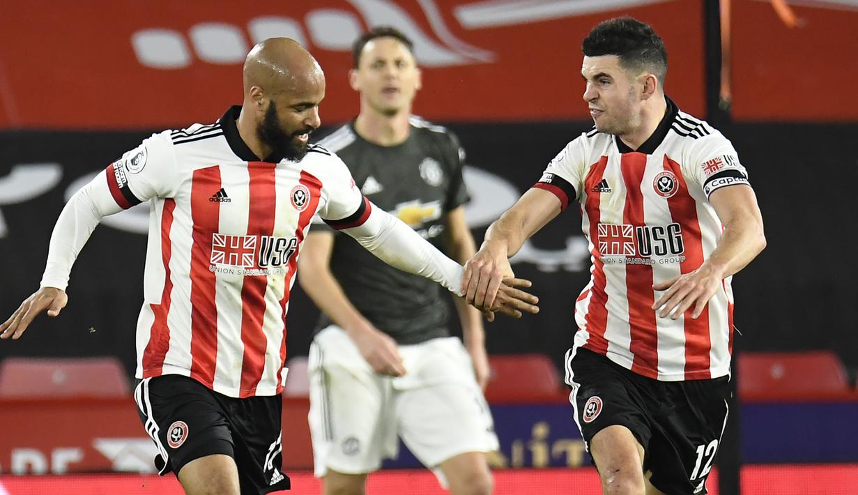 Striker Sheffield United, David McGoldrick (kiri), merayakan gol keduanya ke gawang Manchester United dalam laga lanjutan Liga Inggris 2020/21 pekan ke-13 di Bramall Lane, Sheffield, Kamis (17/12/2020). Sheffield United kalah 2-3 dari Manchester United. (AFP/Peter Powell/Pool)