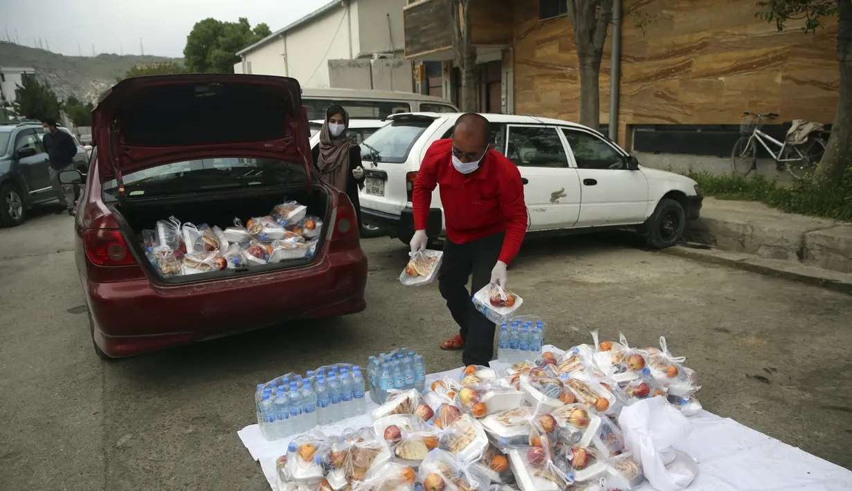 Sukarelawan menyiapkan makanan berbuka puasa gratis untuk orang-orang yang membutuhkan selama bulan puasa suci Ramadan di Kabul, Afghanistan, Kamis (7/5/2020). Muslim di seluruh dunia melewati Ramadan tahun ini di tengah pandemi virus corona COVID-19 dan PHK. (AP Photo/Rahmat Gul)