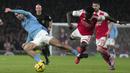 Pemain Manchester City, Jack Grealish (kiri) berebut bola dengan pemain Arsenal, Bukayo Saka pada laga pekan ke-23 Liga Inggris 2022/2023 yang berlangsung di Emirates Stadium, London, Kamis (16/02/2023) WIB. The Cityzens berhasil menang dengan skor 3-1. (AP Photo/Kin Cheung)