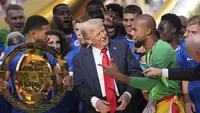 Presiden Donald Trump berbicara dengan kiper Chelsea Robert Sanchez saat Reece James memegang trofi juara setelah laga final Piala Dunia Antarklub antara Chelsea dan PSG di MetLife Stadium, New Jersey, 13 Juli 2025. (AP Photo/Jacquelyn Martin)