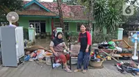 Keluarga ibu Haji Mamah Rusmahwati berpose di depan kediamannya Desa Sumber Urip Pebayuran, Kabupaten Bekasi, Jawa Barat, Senin (22/2/2021). Banjir merenda keluarga tersebut merapikan barang-barang dan bersihkan rumah yang sudah surut. (Liputan6.com/Herman Zakharia)