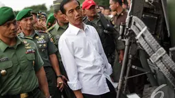 Presiden Jokowi memperhatikan sebuah senjata saat di Pameran  Alutsista TNI AD, Jakarta, Rabu (17/12/2014). (LIputan6.com/Faizal Fanani)