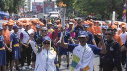 Pebalap sepeda legendaris Indonesia, Sutiyono, bersiap mengikuti pawai obor Asian Games XVIII di Lampung, Rabu (8/8/2018). Sebanyak 53 kota di Indonesia akan dilalui oleh obor Asian Games. (Bola.com/Reza Bachtiar)