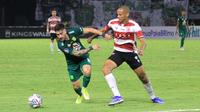 Duel antara pemain Persebaya Surabaya, Higor Vidal dengan pemain Madura United, Cleberson dalam laga di Stadion Gelora Bung Tomo, Minggu (14/8/2022). (Bola.com/Aditya Wany)