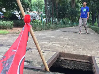 Pejalan kaki melintasi trotoar yang rusak dan berlubang di Jalan Kyai Tapa, Jakarta, Kamis (24/1). Banyaknya lubang akibat kerusakan penutup saluran air tersebut membahayakan pejalan kaki. (Liputan6.com/Immanuel Antonius)