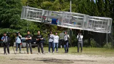 Pemimpin proyek Cartivator, Tsubasa Nakamura (ketiga kiri) menyaksikan uji coba model mobil terbang di kota Toyota, Jepang (3/6). Sebuah perusahaan start up yang disokong oleh Toyota menguji coba prototype dari model mobil terbang. (AP Photo/Koji Ueda)