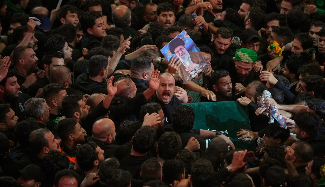Peti jenazah mendiang Pemimpin Tertinggi Iran Ayatollah Ali Khamenei diarak melewati kerumunan pelayat di Makam Imam Hussein di Karbala, Irak, Kamis pagi, 9 Juli 2026. (AP Photo/Khalil Hamra)